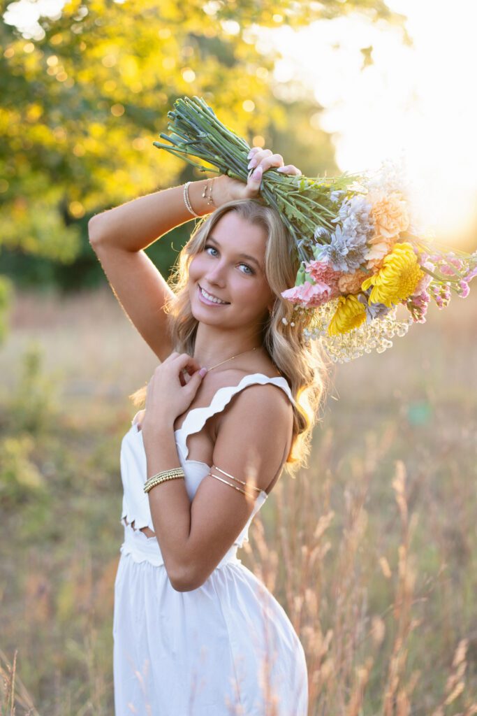 outdoor senior picture idea in field holding flowers