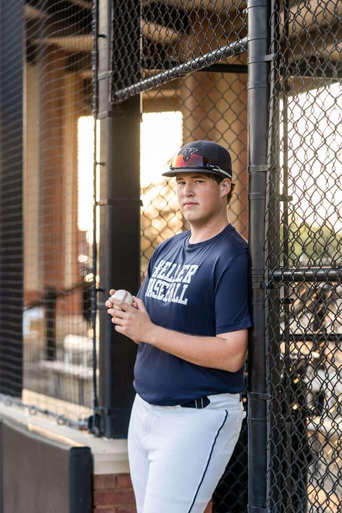 senior guy picture idea wearing baseball jersey at ball park