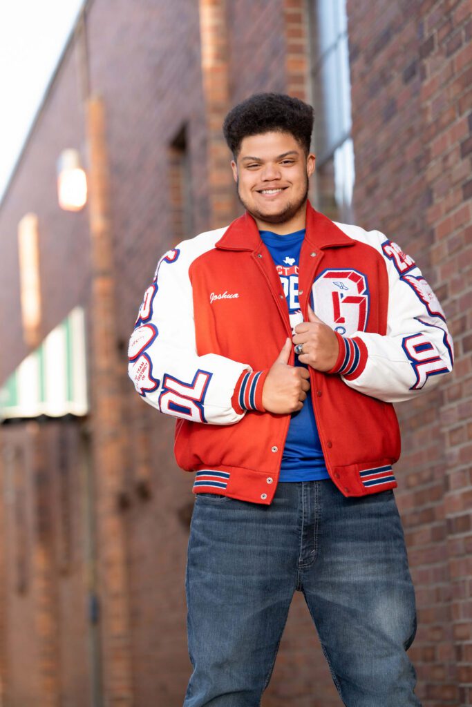senior guy picture idea with letterman jacket in alley